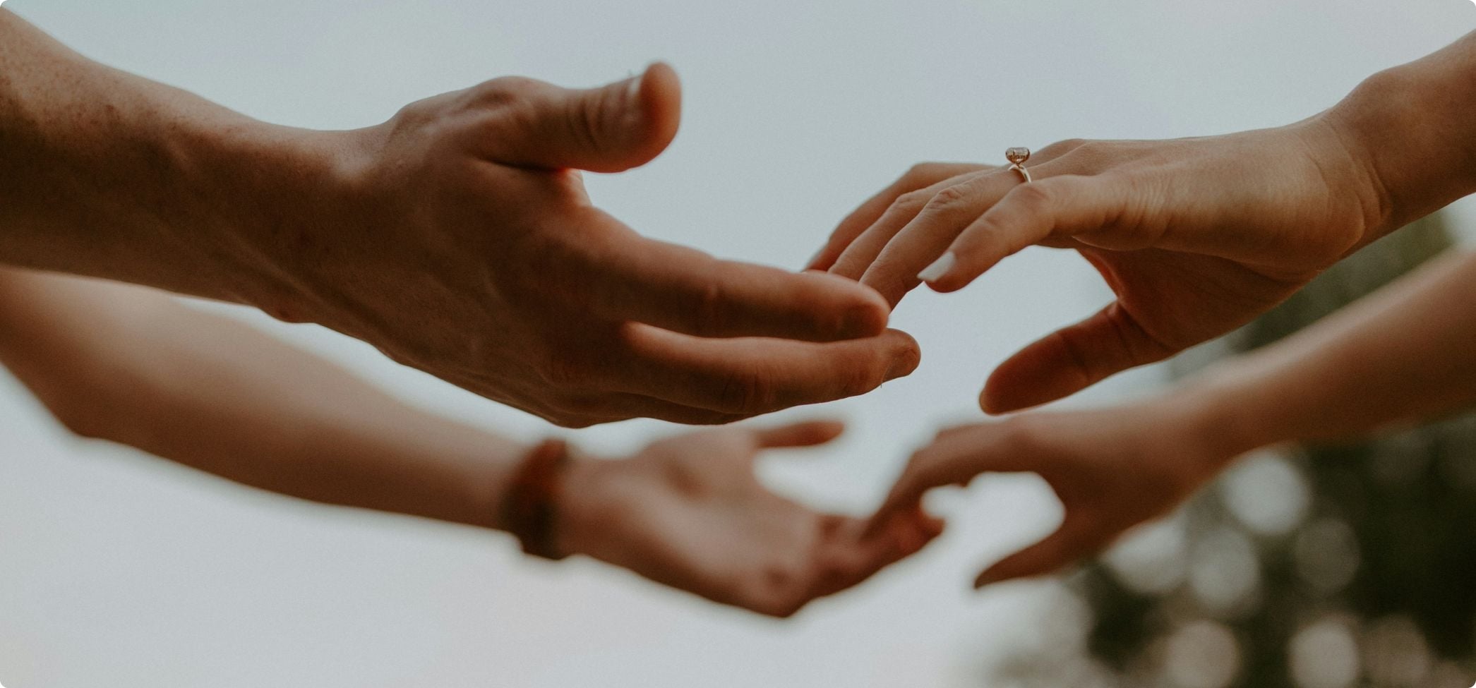Vuxna händer som håller i varandra som symboliserar stöd